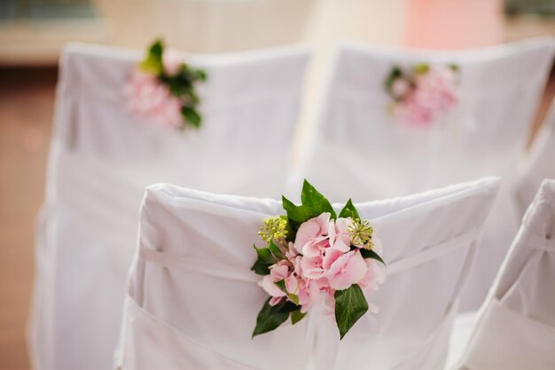 Capas de cadeira de casamento com flores cor de rosa