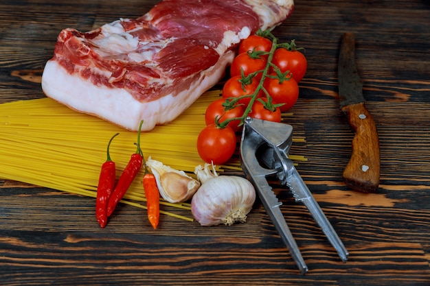 Capas de grasa cruda con carne, pimienta y sal en mesa de madera