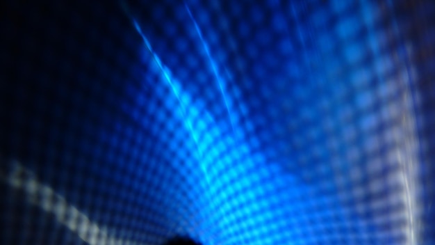 Las capas de luz azules rítmicas progresivas se ven a través de un patrón de valla de red
