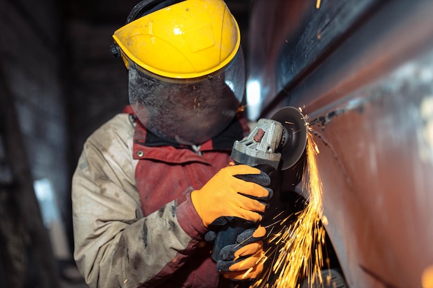 capataz masculino trabalhando com um moedor cortando uma reparação de carroceria de carroceria