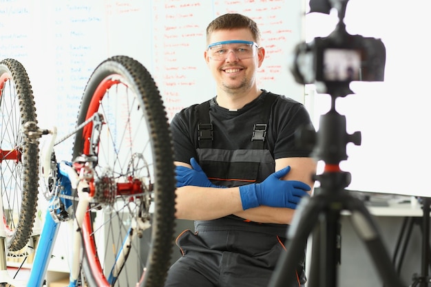 El capataz sonriente toma una foto de la reparación de bicicletas en la cámara