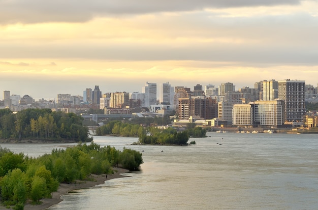 La capital de Siberia en los grandes puentes fluviales de Siberia sobre el agua una exuberante vegetación en el río