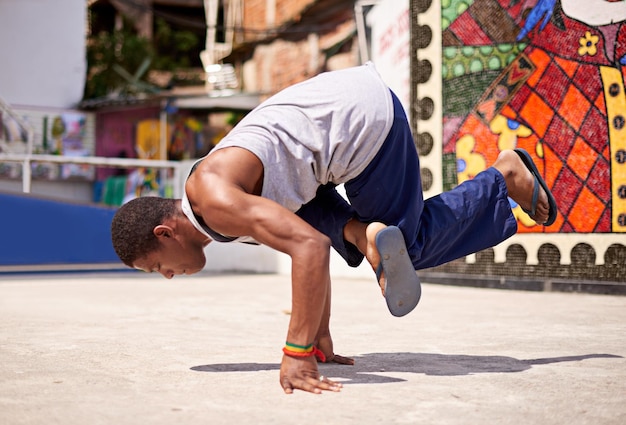 Capoeira cultura Tiro de ángulo bajo de un joven breakdancer masculino en un entorno urbano