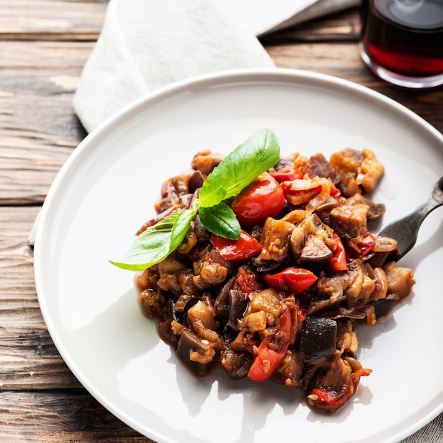 Caponata de prato tradicional de berinjela sicilana na mesa de madeira, foco seletivo e imagem quadrada