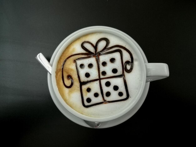 Cappuccino com decoração em formato de caixa para presente. Vista do café da manhã