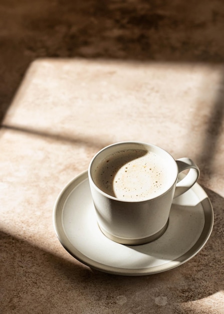 Cappuccino com espuma em luz dura com belas sombras isoladas Conceito de pausa para café Copiar espaço