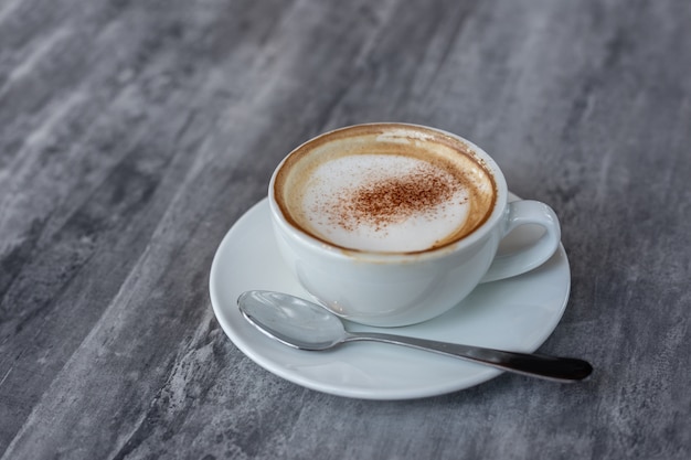 Cappuccino creme em cima da xícara de café na mesa de pedra