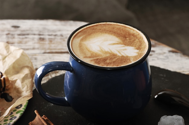 Cappuccino em caneca azul com espuma de leite bonito