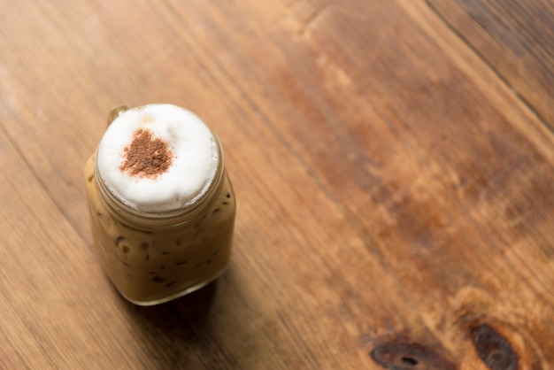 Cappuccino helado en la mesa de madera en el restaurante de la cafetería