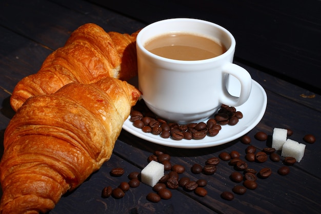 Cappuccino in einer Tasse und Croissant. Beliebtes Frühstück.