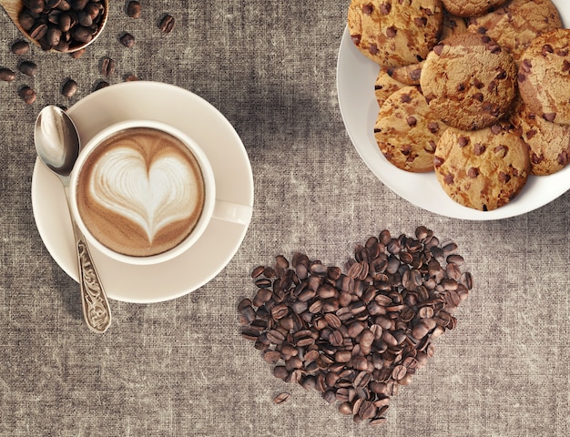 Cappuccino-Kaffeebohnen in Herzform und hausgemachte Schokoladenkekse in einem Kaffeehaus