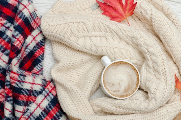 Cappuccino, Milchstrickpullover. kariertes Plaid und Herbstlaub