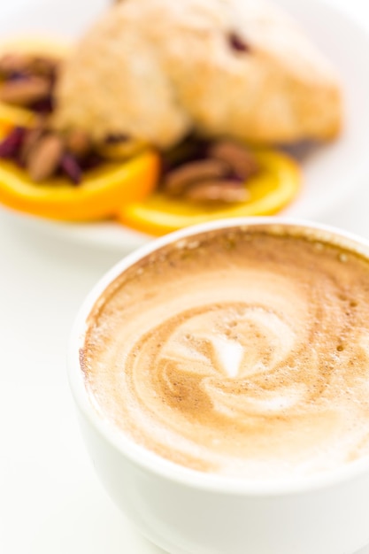 Cappuccino mit frischem Cranberry-Orangen-Scone zum Frühstück.