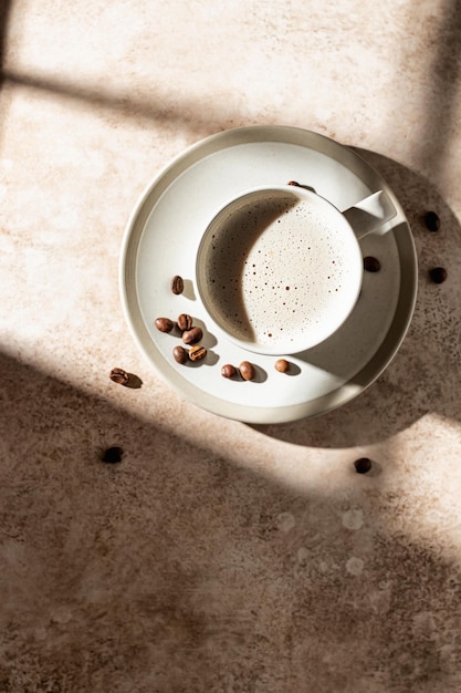 Cappuccino mit Schaum in hartem Licht mit isolierten Schatten Kaffeepausenkonzept Draufsicht auf den Textbereich