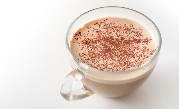 Cappuccino mit Schokolade auf weißem Marmor in einer transparenten Glasschale