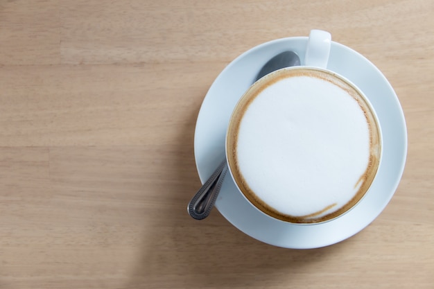 Foto cappuccino quente em copo branco na mesa de madeira com espaço de cópia