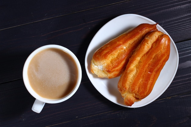 Cappuccino und Brandteig auf einem dunklen