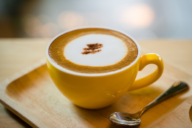 Cappucino quente com pequena colher na mesa