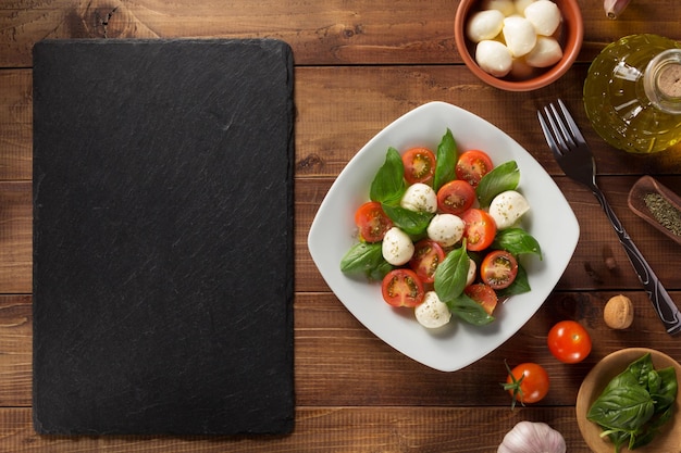 Foto caprese-salat im teller am holz