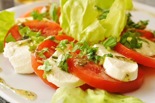 Caprese-Salat mit Mozzarella-Käse, Tomaten und grünem Salat im Restaurant