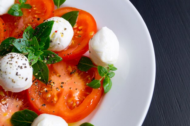 Caprese-Salat mit reifen Tomaten und Mozzarella mit frischen Basilikumblättern. Italienisches Essen.