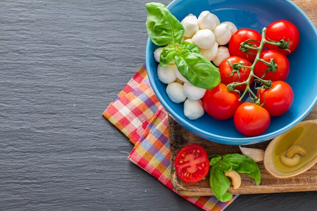 Caprese-Salatbestandteile auf dunklem Steinhintergrund