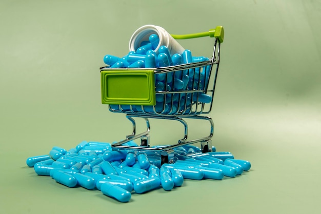 Cápsula de medicamento azul em carrinho de compras em miniatura
