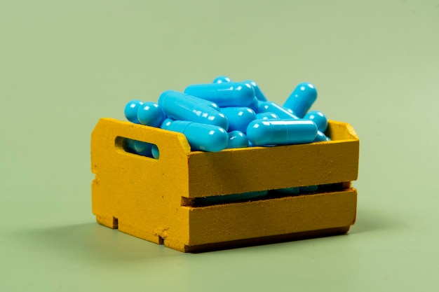 cápsula de medicamento azul em carrinho de compras em miniatura