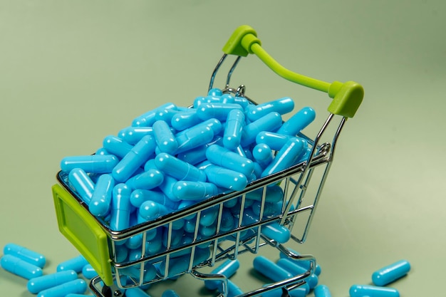 cápsula de medicamento azul num carrinho de compras em miniatura