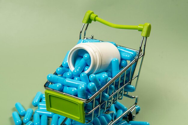 Foto cápsula de medicamento azul en un carrito de compras en miniatura