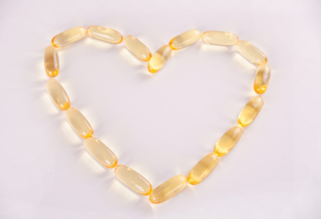 Cápsulas de aceite de pescado en forma de corazón Omega 3 o vitamina E. Vitaminas para la promoción de la salud.