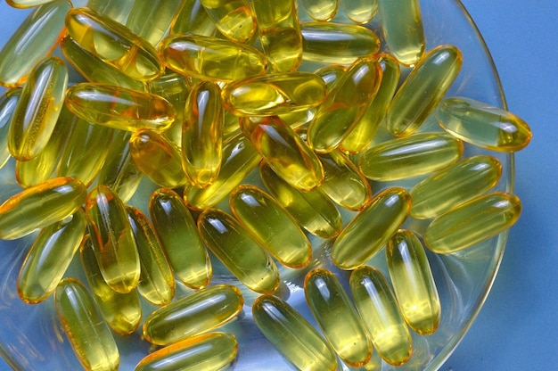 Cápsulas de aceite de pescado en una placa de vidrio. Mucha vitamina omega 3. Primer plano.