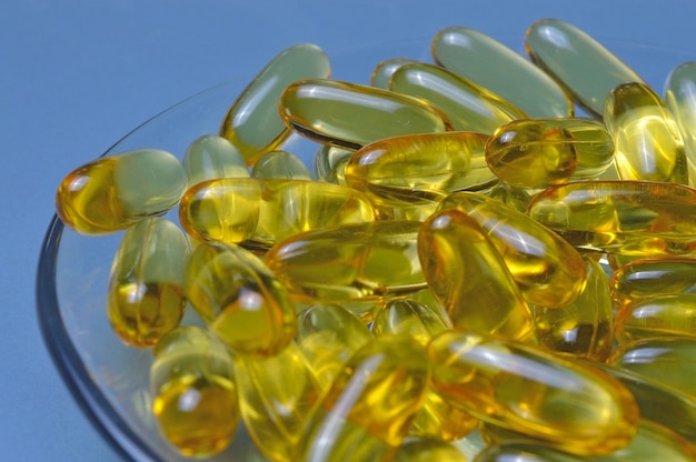 Cápsulas de aceite de pescado en una placa de vidrio. Mucha vitamina omega 3. Primer plano.