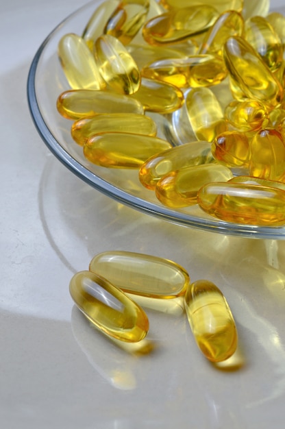 Cápsulas de aceite de pescado con vitamina D en una placa de vidrio