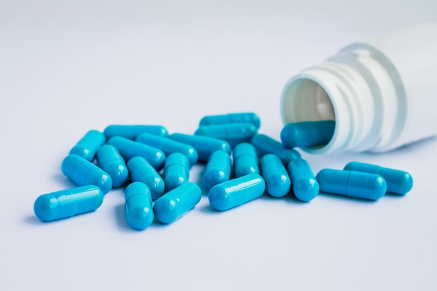 Foto cápsulas azuis, comprimidos em um fundo azul claro