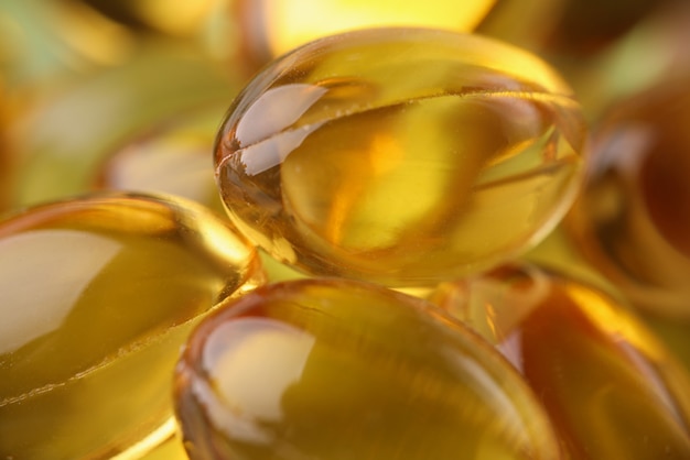 Cápsulas transparentes douradas em embalagem orgânica closeup