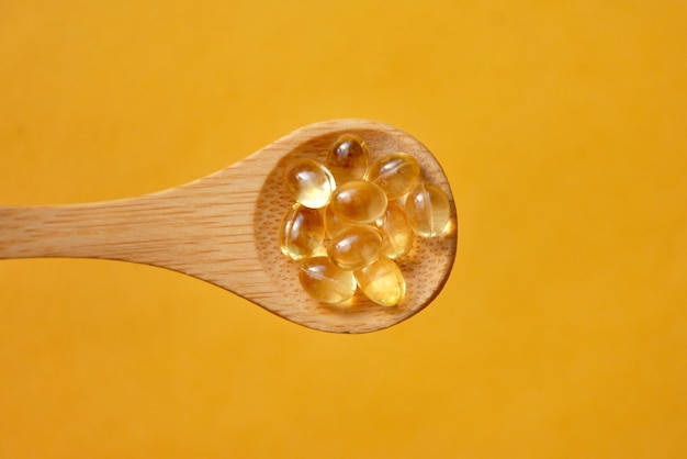 Cápsulas con vitaminas en una cuchara Un complejo de vitaminas para la salud.