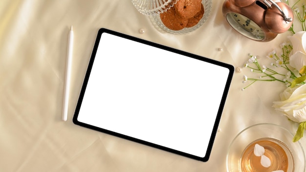 Captura aérea de uma mesa de trabalho feminina com maquete de tela branca de computador tablet digital