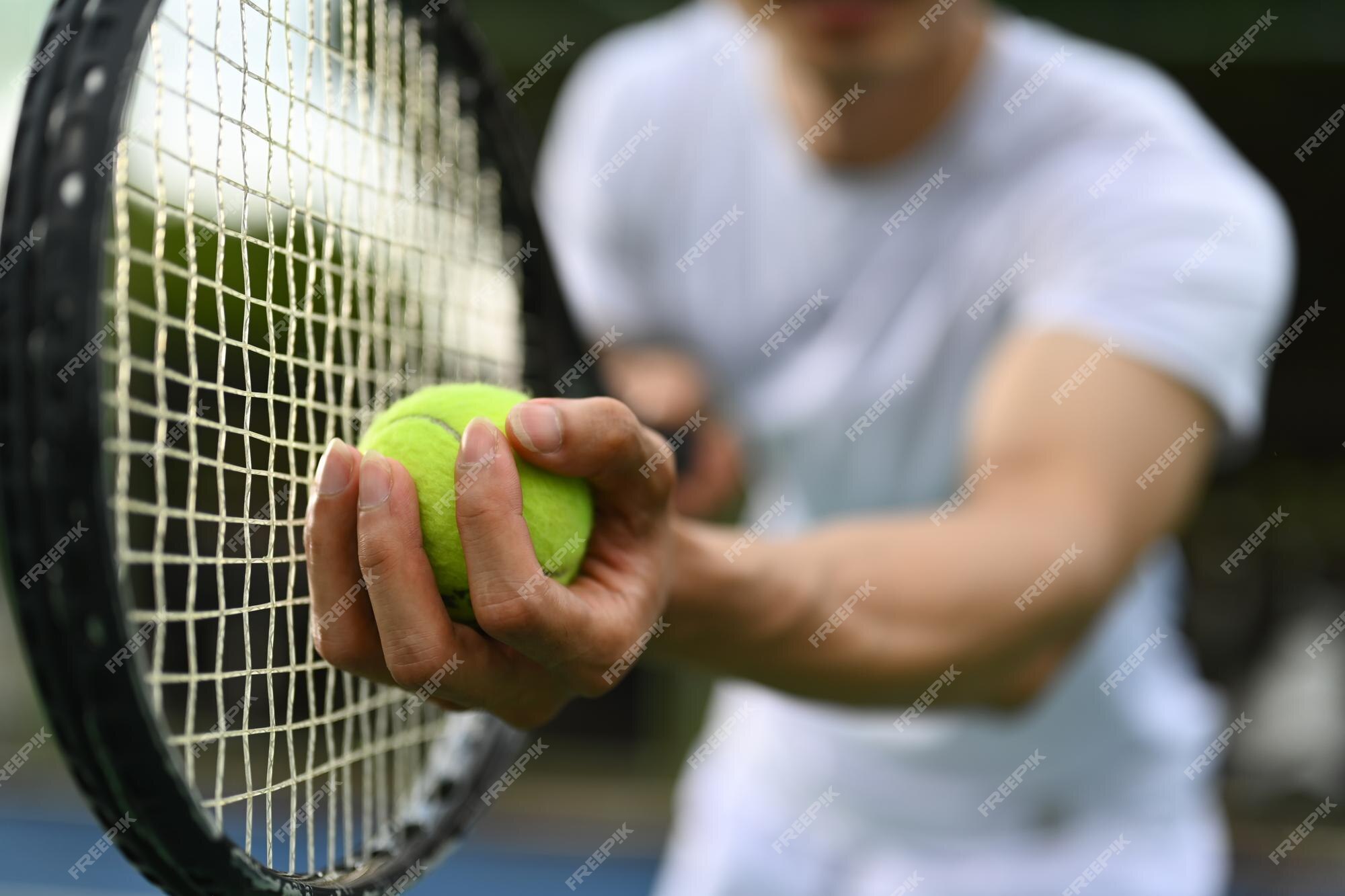 Captura aproximada da mão do tenista masculino segurando a bola de tênis e  o jogo de partida da raquete ou servindo a bola durante a partida