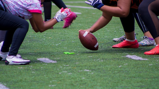 Captura aproximada de jogadores de futebol americano iniciando uma partida em um campo verde