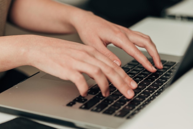 Foto captura aproximada de mãos humanas colocadas sobre o laptop