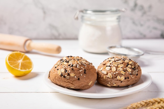 Captura aproximada de pãezinhos saudáveis de sementes de cereais mistos multigrãos recém-assados em um prato branco