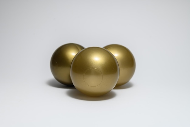 Captura aproximada de três bolas de ouro sobre um fundo cinza