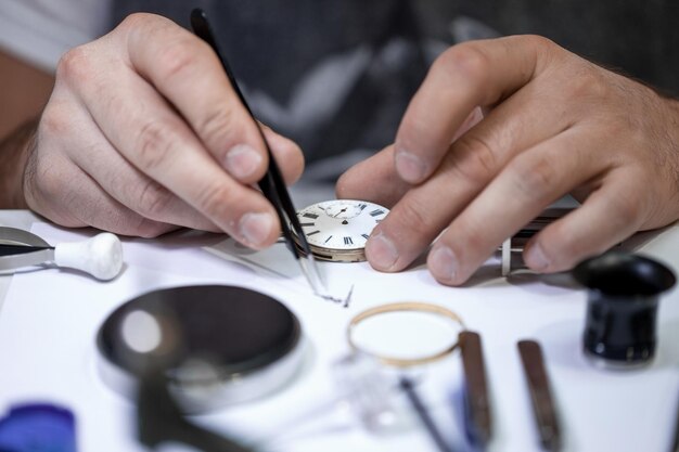 Foto captura aproximada de um artesão consertando engrenagens em um relógio