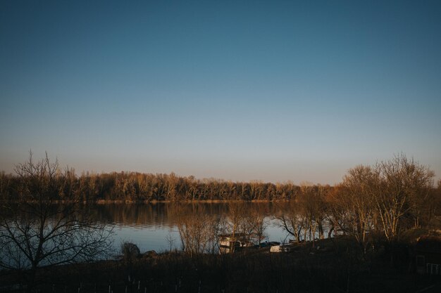 Captura aproximada de um lago sob um céu claro ao pôr do sol