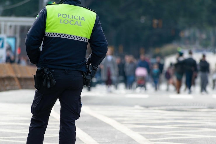 Foto captura aproximada de um policial com "polícia local" escrito no uniforme em espanhol