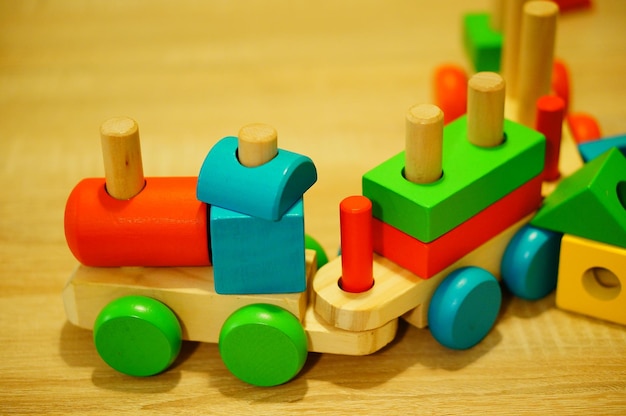 Captura aproximada de um trem de brinquedo com blocos coloridos em uma superfície de madeira