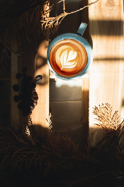 Captura aproximada de uma xícara de café branco, cappuccino quente com arte em forma de coração e comida de flores e