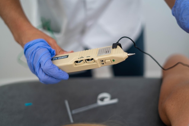 Captura de foco raso de um médico segurando uma caneta de acupuntura do procedimento