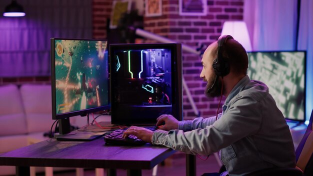 Captura de mão do jogador transmitindo um atirador espacial em ritmo acelerado na configuração do PC para jogos enquanto explica a jogabilidade aos assinantes. Homem caucasiano jogando jogo de ação online multiplayer falando com a equipe no fone de ouvido.